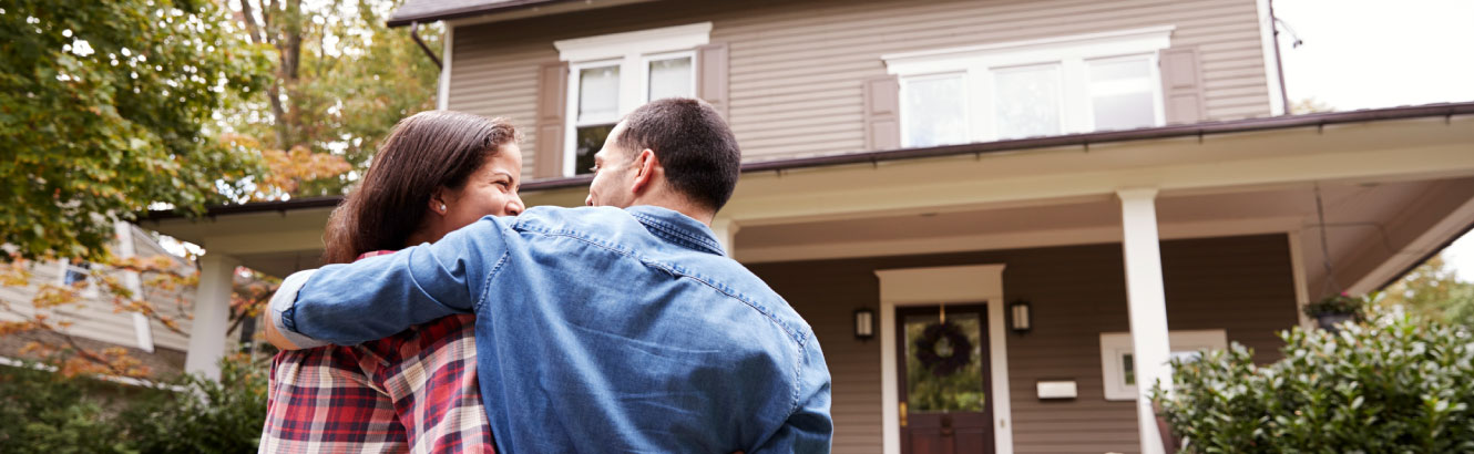 a couple in front of their new home